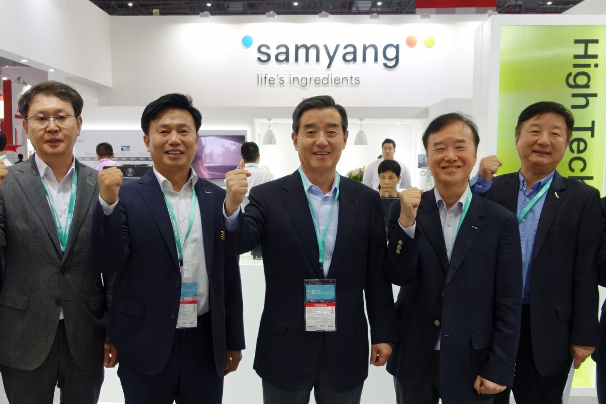 ▲‘차이나플라스 2018’을 방문한 삼양그룹 김윤 회장(가운데)이 삼양 부스에서 임직원들과 함께 포즈를 취했다. (사진제공=삼양그룹)