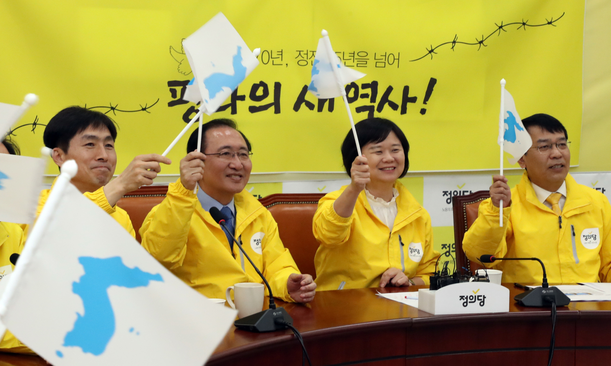 ▲정의당 이정미 대표와 노회찬 원내대표 등이 27일 국회에서 한반도기를 흔들며 남북정상회담을 TV로 시청하고 있다.(연합뉴스)