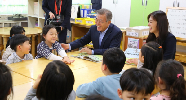 ▲문재인 대통령이 4일 오후 서울 성동구 경동초등학교를 찾아 독서활동을 하고 있는 돌봄 교실을 방문해 탤런트 장신영 씨가 읽어준 ‘난 무서운 늑대라구’의 교훈을 어린이들과 얘기하다 밝게 웃고 있다.(연합뉴스)