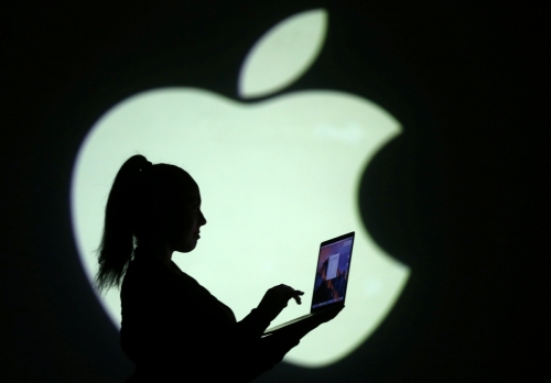 ▲한 여성이 애플 로고 앞에서 노트북을 이용하고 있다. 애플과 삼성전자 간 디자인 특허소송이 14일(현지시간) 시작해 주목을 끌고 있다. 로이터연합뉴스
