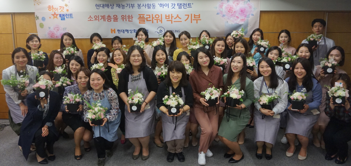 ▲현대해상 직원들이 손수 만든 플라워박스를 들고 기념사진을 찍고 있다. 해당 박스는 호스피스 병동 등에 전달됐다.  사진제공 현대해상