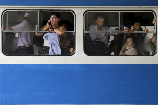 ▲지난해 7월 28일 북한 평양 시내를 지나는 통근 전차 모습. 차창에 팔을 기댄 젊은 남성이 휴대전화로 통화하고 있다.  AP뉴시스