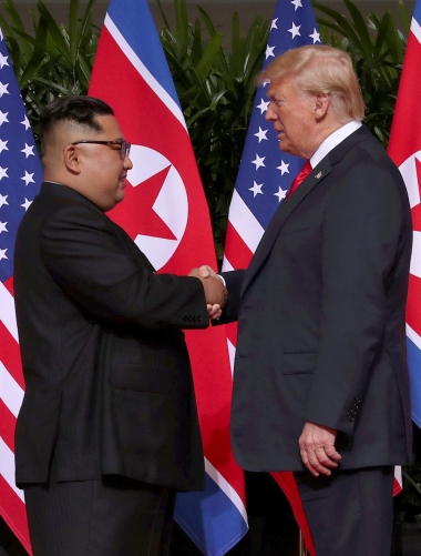 ▲도널드 트럼프(오른쪽) 미국 대통령과 김정은 북한 국무위원장이 12일(현지시간) 북미정상회담에 앞서 악수하고 있다. 싱가포르/로이터연합뉴스