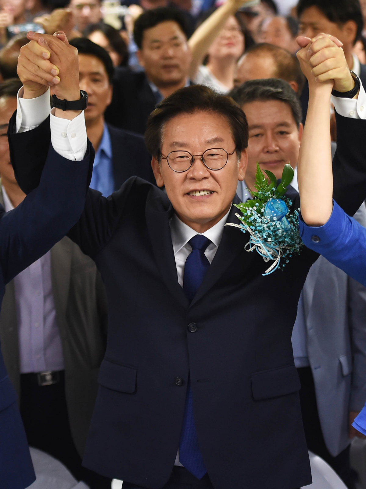 ▲이재명 더불어민주당 경기지사가 지난 13일 오후 경기 수원 팔달구 명캠프에서 참석자들과 함께 손을 맞잡고 기념촬영하고 있다.(뉴시스)