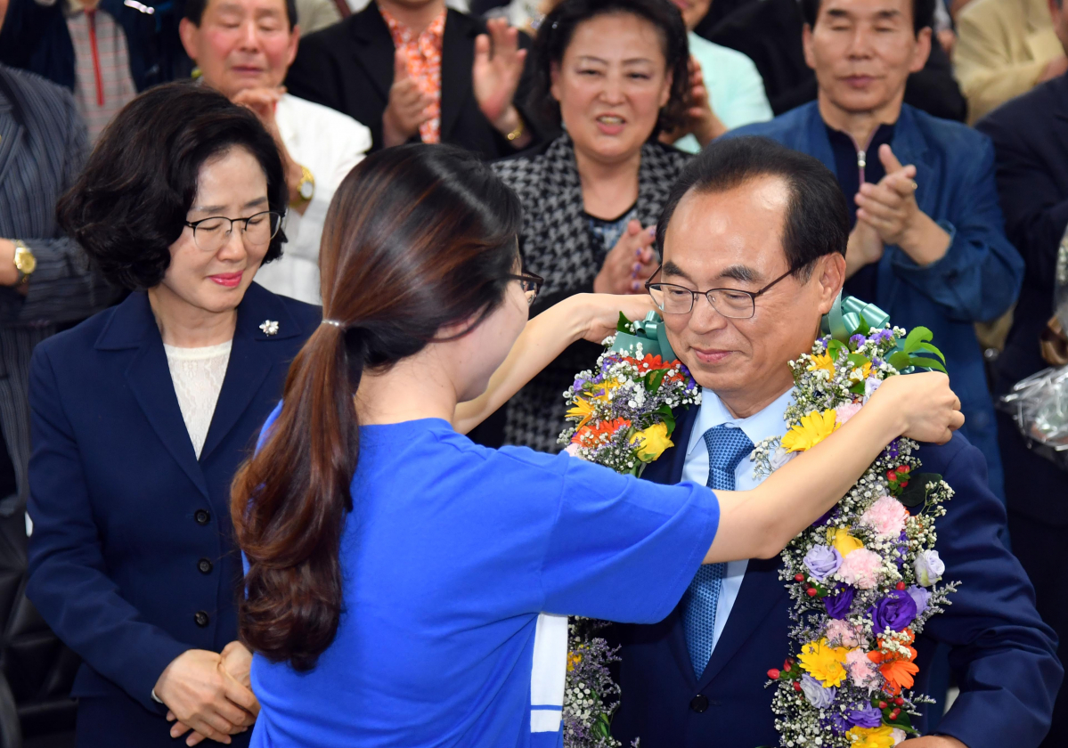 ▲ 전국동시지방선거일인 13일 부산 부산진구 더불어민주당 오거돈 부산시장 후보 선거캠프에서 오 후보가 당선이 확실해지자 캠프 관계자의 축하를 받고 있다. (뉴시스)