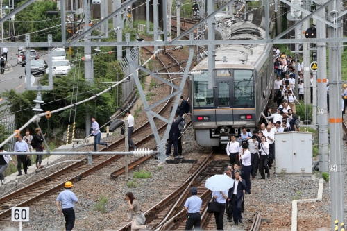 ▲일본 오사카에서 18일(현지시간) 규모 6.1 강진으로 철도가 멈춘 가운데 통근객들이 철로 옆을 걸어서 이동하고 있다. 오사카/EPA연합뉴스
