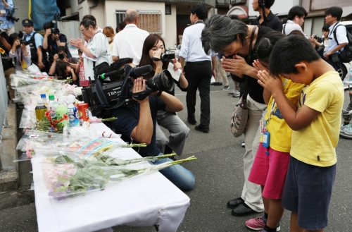 ▲일본 오사카에서 19일(현지시간) 시민이 전날 발생한 강진으로 담벼락이 무너져 사망한 초등학생의 넋을 기리고 있다. 현재 이번 지진으로 인한 사망자는 5명으로 집계됐다. 오사카/EPA연합뉴스

