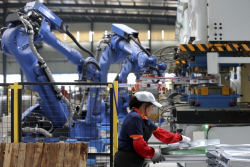 ▲중국 안후이성 쑤이시현의 에어컨 제조공장에서 노동자가 산업 로봇과 함께 일하고 있다. 쑤이시/AP연합뉴스
