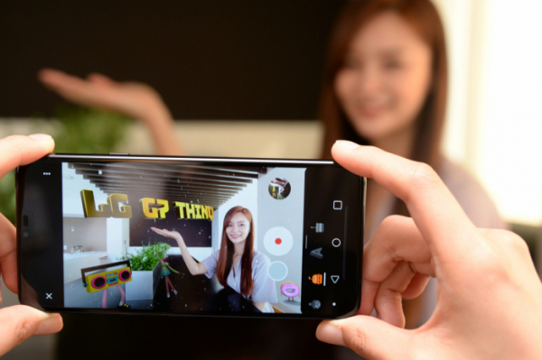 ▲LG전자가 LG G7 ThinQ에 새로운 '증강현실(AR) 스티커' 카메라 모드를 추가하는 업그레이드를 시작했다. 사진은 모델이  'AR 스티커' 기능을 활용해 사진을 촬영하고 있는 모습.(사진=LG전자)