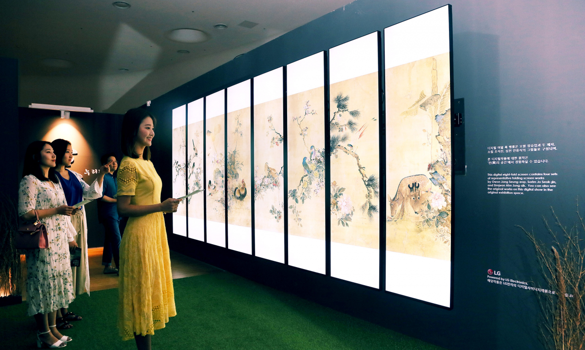 ▲서울 중구 동대문 디자인 플라자(DDP)에서 '조선 최후의 거장, 장승업 X 취화선展'을 찾은 관람객들이 LG 전자 울트라 스트레치 사이니지 8장으로 조성한 디지털병풍에서 장승업의 화조도를 감상하고 있다.(사진제공=LG전자)