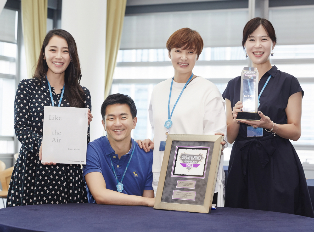 ▲삼성화재 브랜드전략파트 직원들이 '2018 아스트리드 어워드' 그랑프리를 수상한 연차보고서와 상패, 트로피를 들고 기념사진을 찍고 있다.(삼성화재)