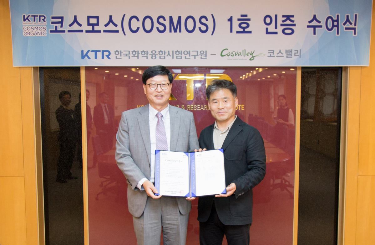 ▲최만현 한국화학융합시험연구원(KTR) 부원장(왼쪽)이 16일 과천 KTR 본원에서 송만근 코스밸리화장품 대표(오른쪽)에게 코스모스 인증서를 전달하고 있다.(한국화학융합시험연구원)