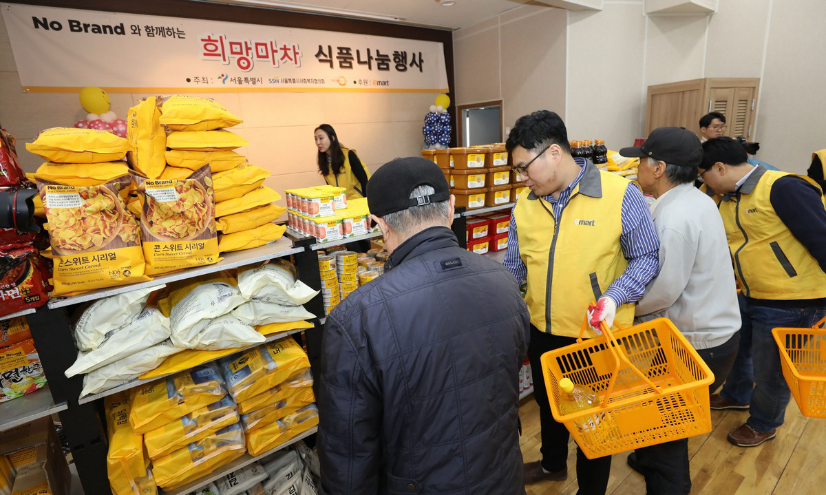 ▲이마트 직원이 ‘희망배달마차 식품 나눔 행사’에서 시민들이 생필품을 고르는 것을 돕고 있다.  사진제공 이마트