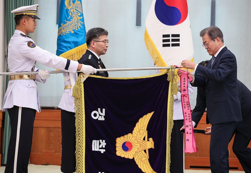 ▲문재인 대통령이 24일 오후 청와대에서 민갑룡 신임 경찰청장에게 임명장을 수여한 뒤 경찰청 깃발에 민생경찰 수치를 달아주고 있다.(연합뉴스)