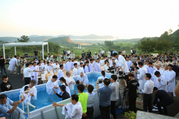 ▲아일랜드CC 임직원과 캐디들이 18일 목회자들의 인도로 침례를 받고 있다. (사진제공=아일랜드 리조트)
