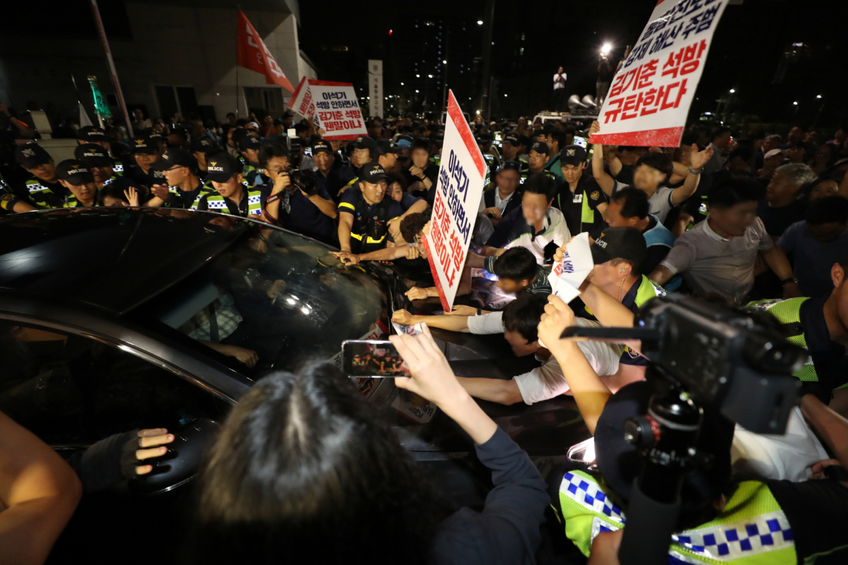 ▲6일 김기춘 전 대통령 비서실장이 석방된 후 탑승한 귀가 차량을 시위대들이 막아서고 있다. (사진=연합뉴스)