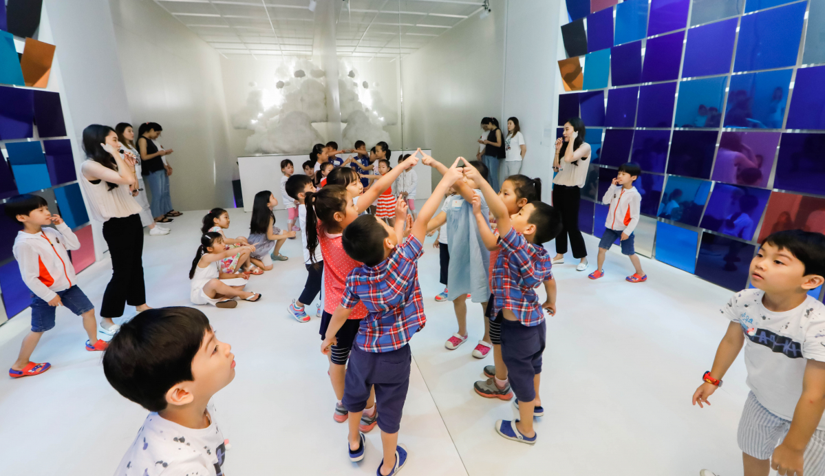 ▲대림그룹 임직원 자녀들이 미술관 도슨트의 설명과 함께 디뮤지엄 ‘Weather: 오늘, 당신의 날씨는 어떤가요?’ 전시를 관람하고 있다.(사진=대림산업)