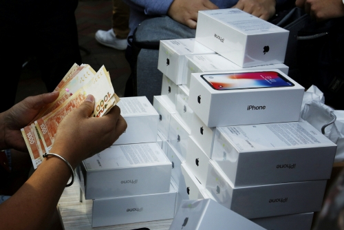 ▲지난해 7월 홍콩 애플스토어에서 한 남성이 아이폰X을 사기 위해 돈을 세고 있다. 홍콩/로이터연합뉴스
