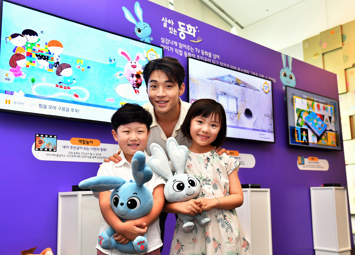 ▲가수 헨리가 7일 서울 을지로 SK텔레콤 본사 수펙스홀에서 열린 SK브로드밴드 기자간담회에 참석해 어린이 모델들과 ‘살아있는 동화’ 서비스를 소개하고 있다.사진제공  SK브로드밴드