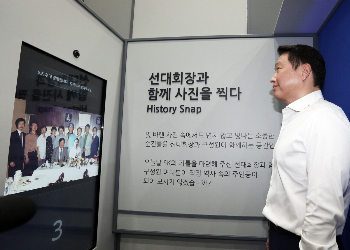 ▲최태원 SK 회장이 14일 서울 종로구 서린동 SK사옥 로비에서 개막한 최종현 SK 회장 20주기 사진전에서 선친 최종현 회장과 사진찍기 체험을 하고 있다. (사진제공=SK)