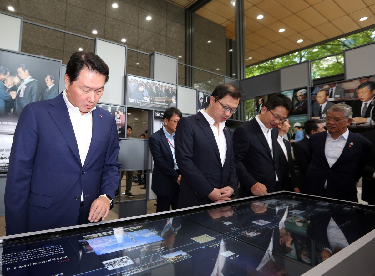 ▲최태원 SK 회장(왼쪽 첫번째)과 최재원 SK 수석부회장(두번째), 최창원 SK 디스커버리 부회장(세번째), 최신원 SK 네트웍스 회장(네번째)이 14일 서울 종로구 서린동 SK사옥 로비에서 개막한 최종현 SK 회장 20주기 사진전에서 전시물을 둘러보고 있다. (사진제공=SK)