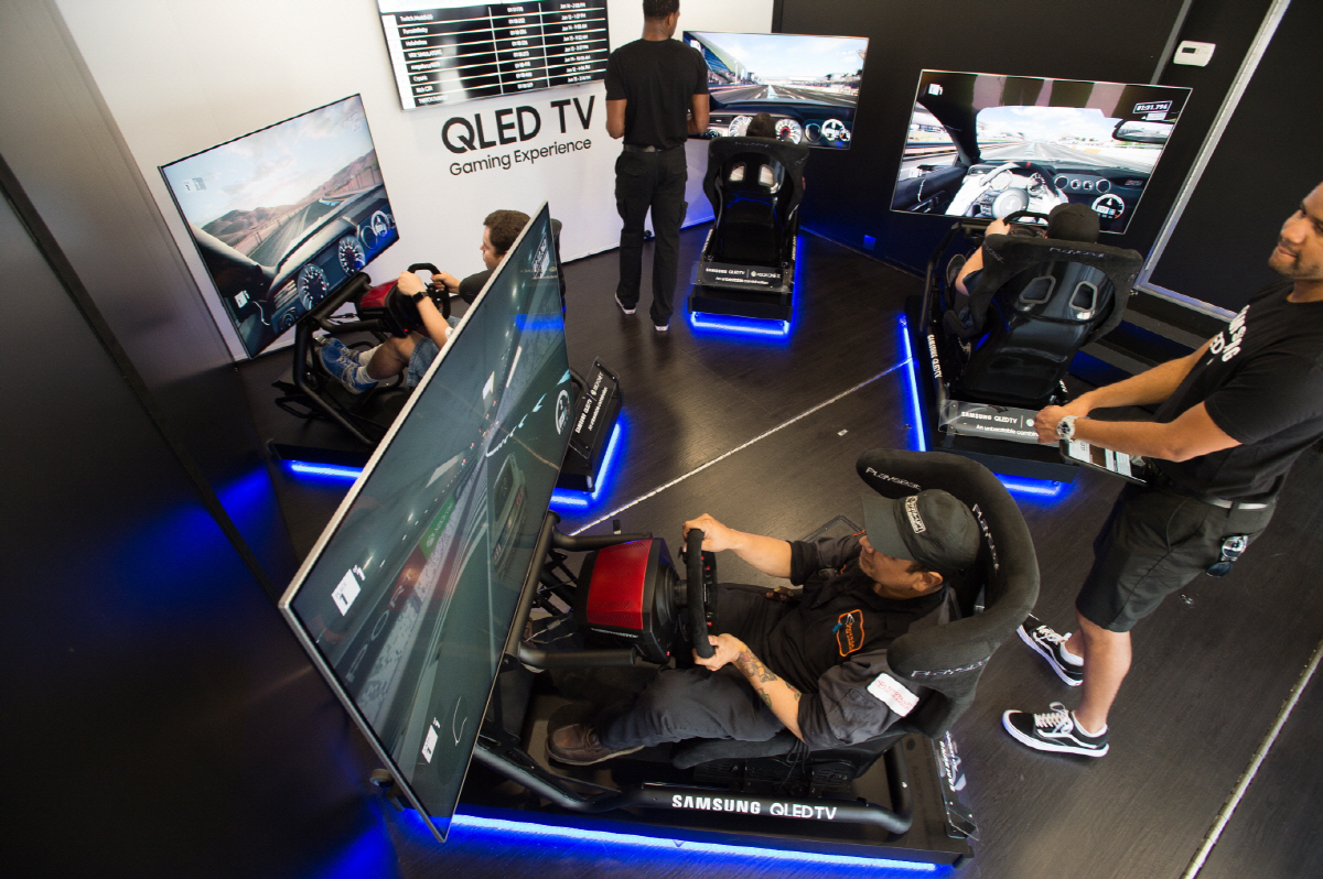 ▲삼성전자는 마이크로소프트(MS) 콘솔 게임기 엑스박스(Xbox)‘와의 협업을 통해 대형 트럭에 ’QLED TV‘ 6대와 ’엑스박스 원 엑스(Xbox One X)‘ 게임기로 구성된 이동형 체험관을 마련했다. 로스앤젤레스에서 체험관 방문객들이 삼성 QLED TV로 엑스박스의 게임을 즐기고 있다. 사진제공 삼성전자