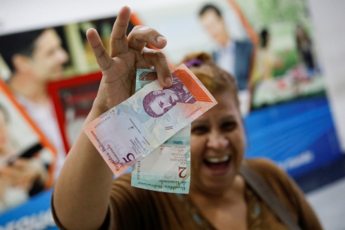 ▲베네수엘라 카라카스에서 한 주민이 20일(현지시간) 새 화폐인 ‘볼리바르 소베라노’를 들어보이고 있다. 카라카스/로이터연합뉴스
