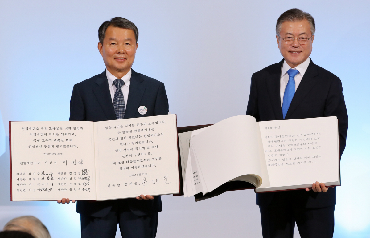 ▲문재인 대통령과 이진성 헌법재판소장이 31일 오전 서울 종로구 헌법재판소에서 열린 창립 30주년 기념식에서 헌법 재판관 10인의 서명이 담긴 순한글판 헌법 책자에 서명한 뒤 기념촬영을 하고 있다.(사진=연합뉴스)