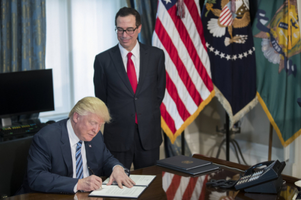 ▲스티븐 므누신(오른쪽) 미국 재무장관이 도널드 트럼프가 서명하는 모습을 보고 있다. (EPA연합뉴스)
