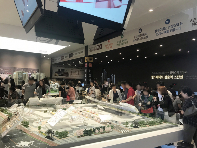 ▲힐스테이트 삼송역 스칸센 견본주택을 찾은 방문객들이 커뮤니티 시설 평면도를 보며 설명을 듣고 있다(사진=현대건설)
