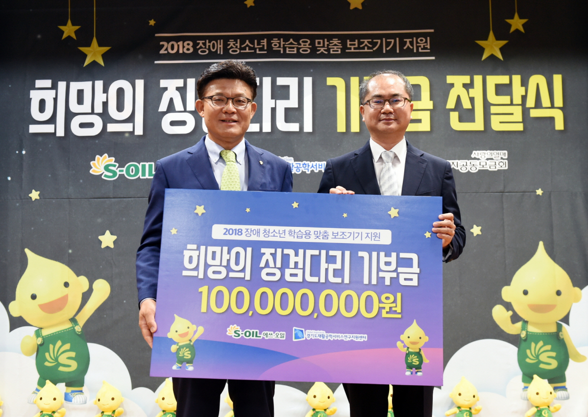 ▲안종범 에쓰오일 수석부사장(왼쪽)이 강인학 경기도재활공학서비스연구지원센터 센터장에게 기부금을 전달한 뒤 기념촬영을 하고 있다. (사진제공=에쓰오일)