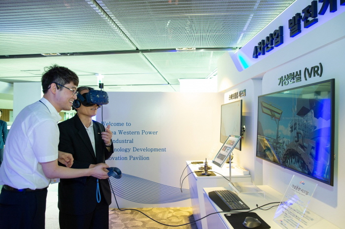 ▲6일 한국서부발전 본사 사옥 2층에 마련된 4차산업 발전기술 혁신관에서 김병숙 서부발전 사장(오른쪽)이 직접 VR을 활용한 가상훈련시스템을 시연하고 있는 모습.(한국서부발전)