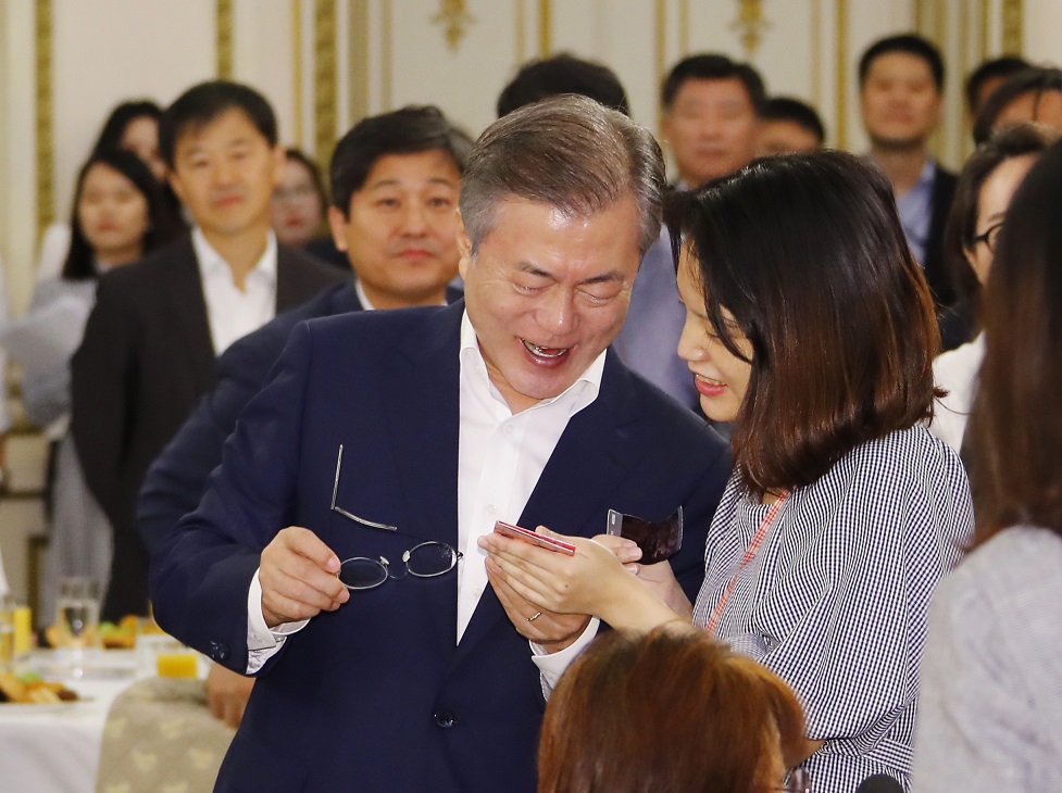 ▲문재인 대통령이 12일 오전 청와대 영빈관에서 열린 '발달장애인 평생케어 종합대책 발표 및 초청 간담회'에 입장하며 다큐멘터리 '어른이되면' 주인공 발달장애인 장혜정씨가 보여주는 사진을 함께 보고 있다.(연합뉴스)