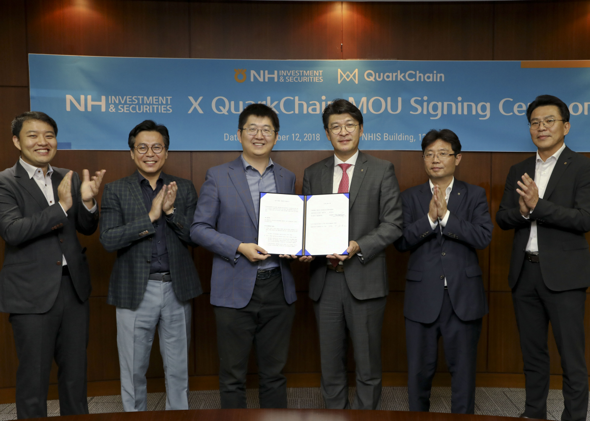 ▲안인성 NH투자증권 디지털본부장(왼쪽에서 네번째)와 쿼크체인 치 조우(왼쪽에서 세번째)대표 및 각사 임직원이 12일 NH투자증권 본사에서 쿼크체인 파운데이션과 업무협약(MOU)을 체결후 기념촬영을 하고 있다.(사진제공=NH투자증권)
