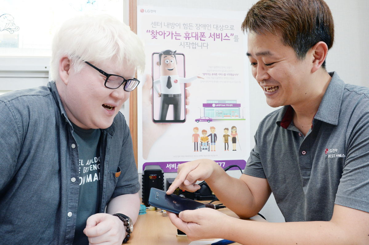▲17일 백색증과 저시력 장애로 외출이 불편한 장애인이 LG전자 '찾아가는 휴대폰 서비스'를 신청해 서울 강남구에 위치한 하상복지관에서 스마트폰 수리를 받고 있다.(사진제공 LG전자)