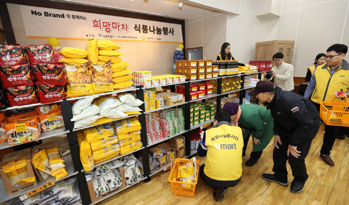 ▲이마트 직원이 ‘희망배달마차 식품 나눔 행사’에서 시민들이 생필품을 고르는 것을 돕고 있다. 사진제공=이마트