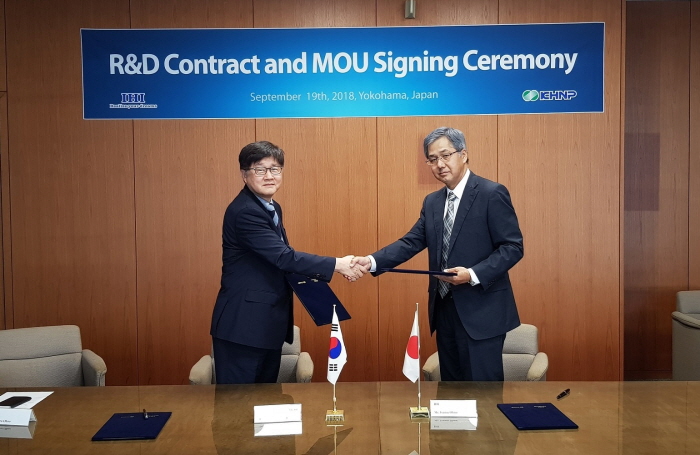 ▲손순환 한국수력원자력 중앙연구원 방사선환경연구소장(왼쪽)과 이사무 오노(Isamu Ohno) IHI사 원자력분야 전무가 19일 후쿠시마 원전 사고로 발생한 방사성폐기물 유리화 실증연구 계약 및 양해각서(MOU)에 서명한 뒤 악수를 하고 있다.(한국수력원자력)