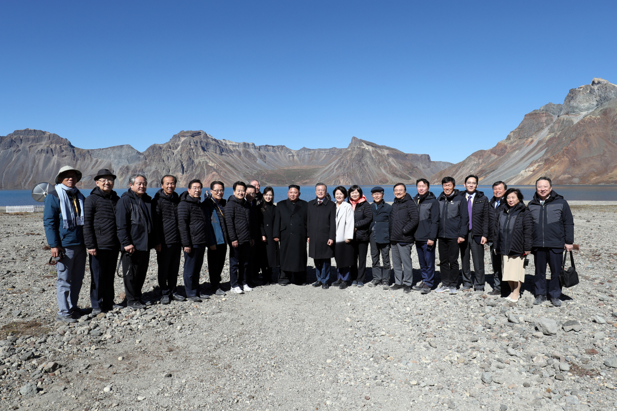 ▲20일 오전 문재인 대통령과 김정은 국무위원장이 백두산 천지에서 남측 수행원들과 함께 기념촬영을 하고 있다.(평양사진공동취재단)