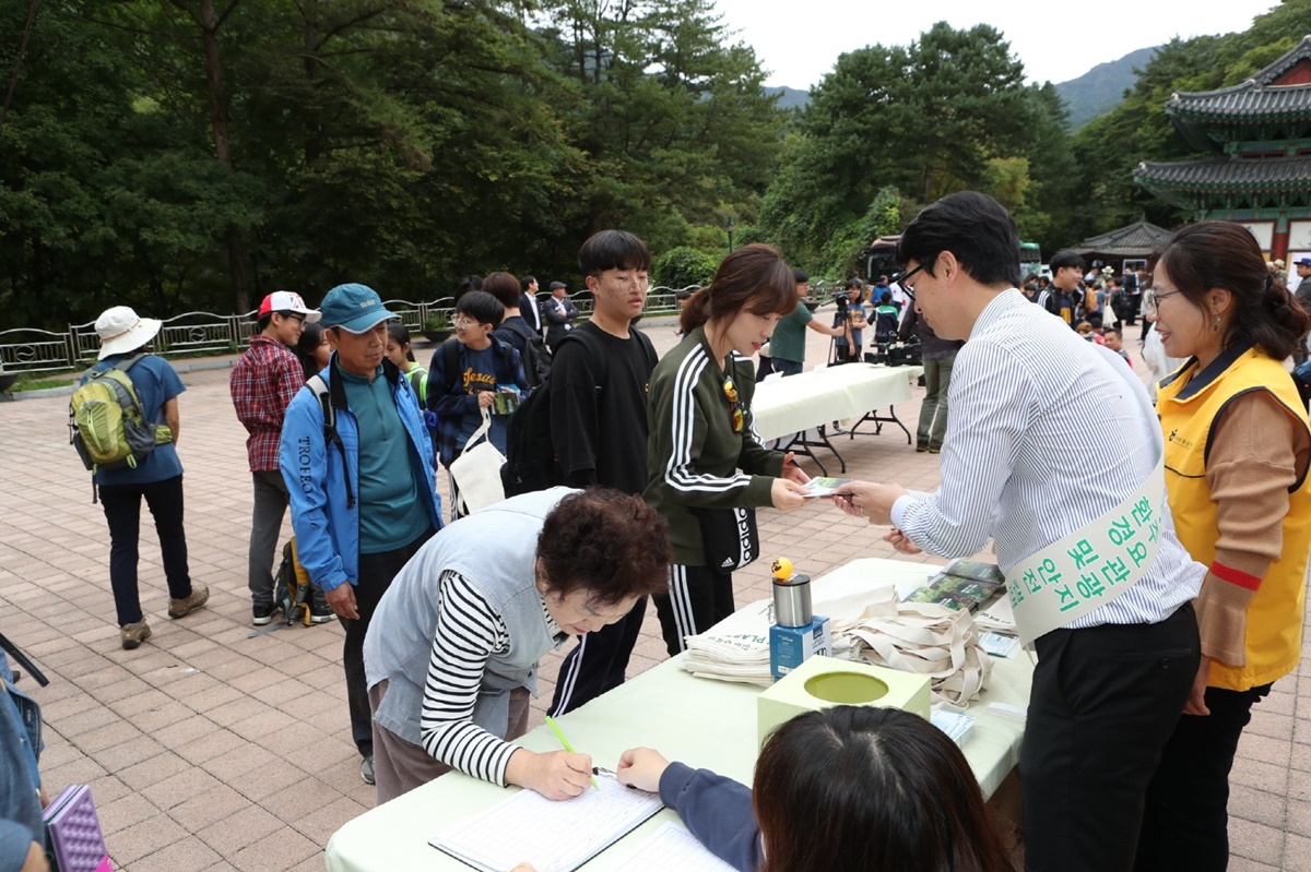 ▲28일 치악산 국립공원 입구에서 한국관광공사, 국립공원관리공단, 대한적십자사가 공동으로 실시한 '관광지 환경보호 및 안전여행 캠페인'에서 방문객이 동참서약을 하고있다.(사진제공=한국관광공사)
