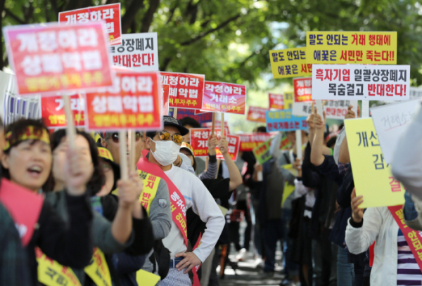 ▲26일 오후 서울 여의도 한국거래소 앞에서 상장폐지가 예고된 11개사 주주들이 상장폐지의 부당함을 주장하며 구호를 외치고 있다.(사진제공=연합뉴스)