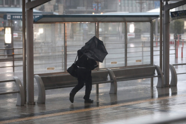 ▲규슈섬의 가고시마에서 태풍 짜미의 강한 바람과 비에 대비해 한 남성이 우산을 들고 서있다. (연합뉴스)