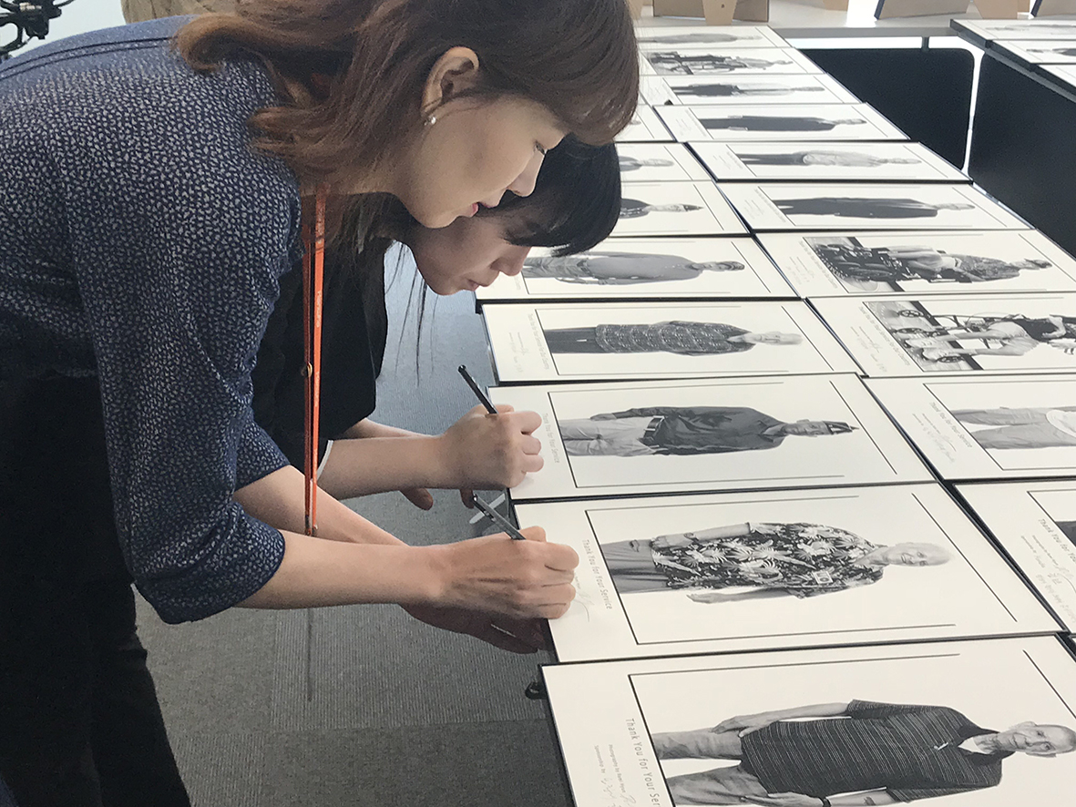 ▲한화그룹 임직원들이 참전용사 사진 액자에 감사 메시지를 적고 있다.(사진 제공=한화)