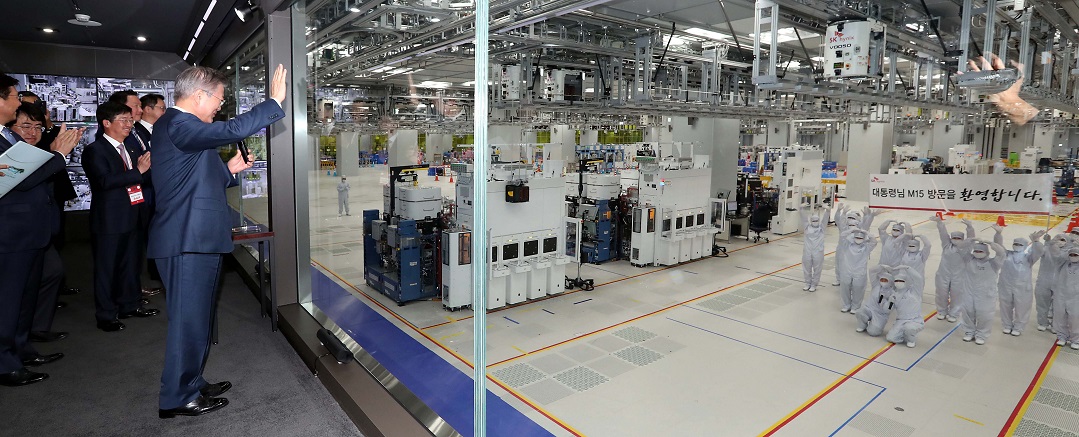▲문재인 대통령이 4일 오전 충북 청주시 흥덕구 SK하이닉스에 준공한 'M15' 반도체 공장에서 청정 공간에서 근무중인 근로자들과 인사하고 있다.(연합뉴스)