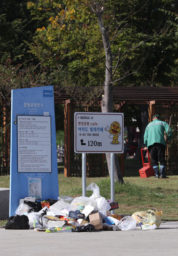 ▲서울세계불꽃축제 다음날인 7일 오전 서울 여의도 한강공원 일대에 쓰레기들이 널부러져 있다.(뉴시스)