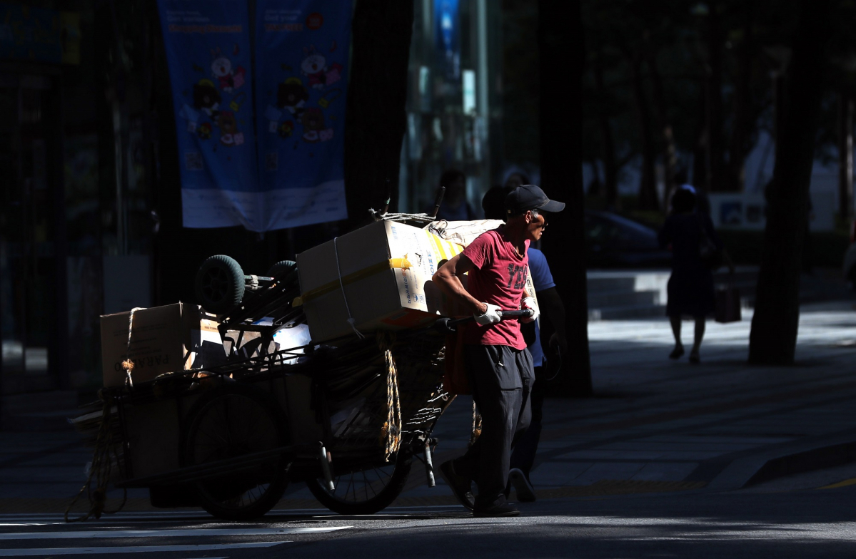 ▲가마솥 무더위가 이어지던 7월 16일 오전 서울 종로구 서울시청 인근 무교로에서 한 노인이 폐지를 가득싫은 리어카를 끓고 있다.(뉴시스)