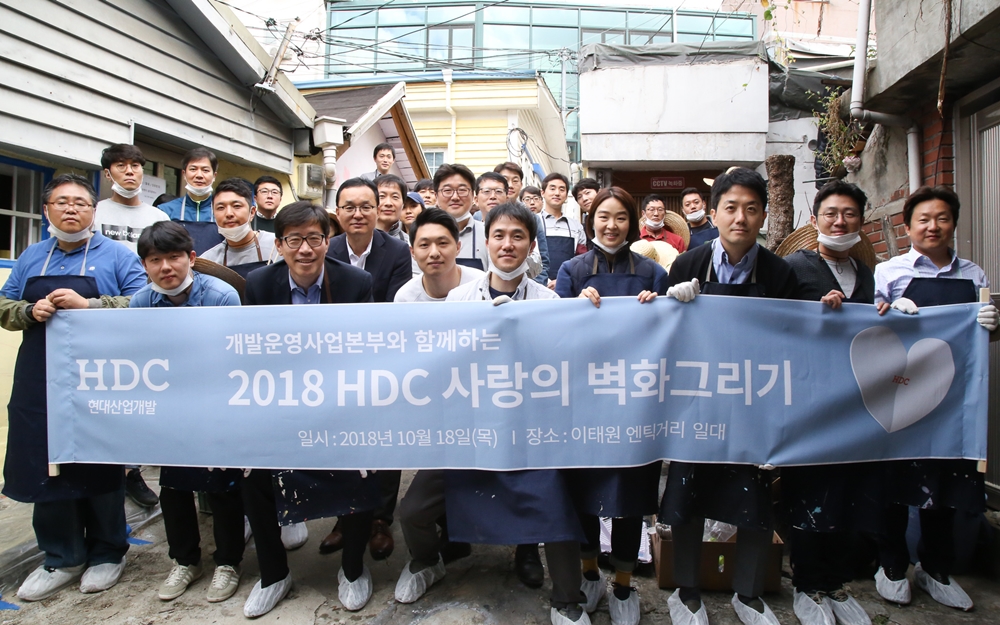 ▲HDC현대산업개발 개발운영사업본부 임직원이 서울 용산구 이태원 앤틱가구거리 보광로 51길 일원에 사회 공헌 활동의 일환으로 ‘HDC 사랑의 벽화그리기’에 참여하고 기념사진을 촬영하고 있다.(사진=현대산업개발)