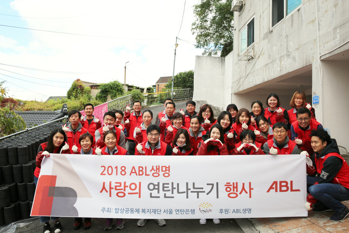 ▲ABL생명 직원 35명이 18일 서울 강북구 수유동에서 연탄 1000장을 홀몸 어르신이 거주하는 가구 5곳에 배달한 뒤 기념사진을 찍고 있다.(사진제공=ABL생명)