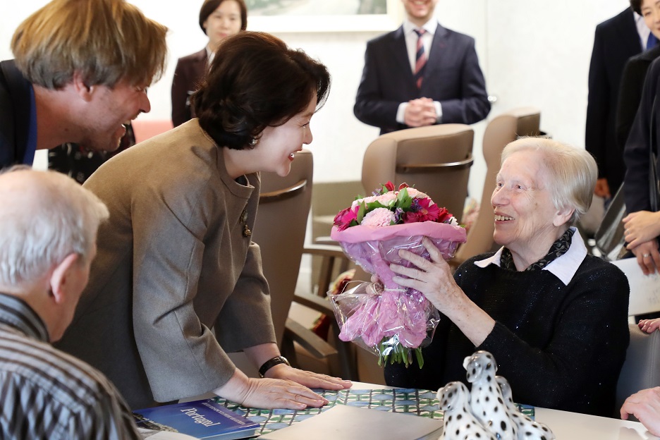 ▲아셈(ASEM·아시아유럽정상회의) 정상회의 참석한 벨기에를 방문중인 김정숙 여사가 19일 오전(현지시간) 루벤의 '드 윈거드' 치매 노인요양시설을 방문해 어르신에게 꽃다발을 선물하고 있다.(브뤼셀/연합뉴스)