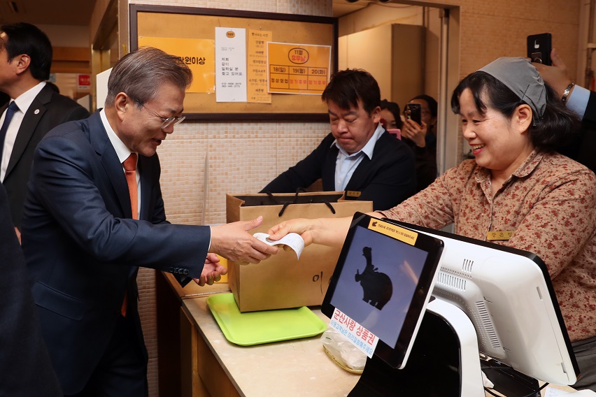 ▲문재인 대통령이 30일 오후 전북 군산의 빵집 이성당을 찾아 빵을 고른 뒤 계산하고 있다.(연합뉴스)