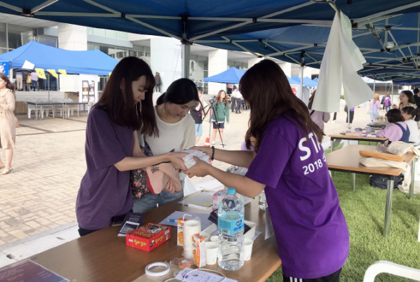 ▲지난달 서울 성북구에서 열린 성신여대 축제 기부 부스에서 재학생이 생리대를 기부하고 있다. (사진제공=성신여대)